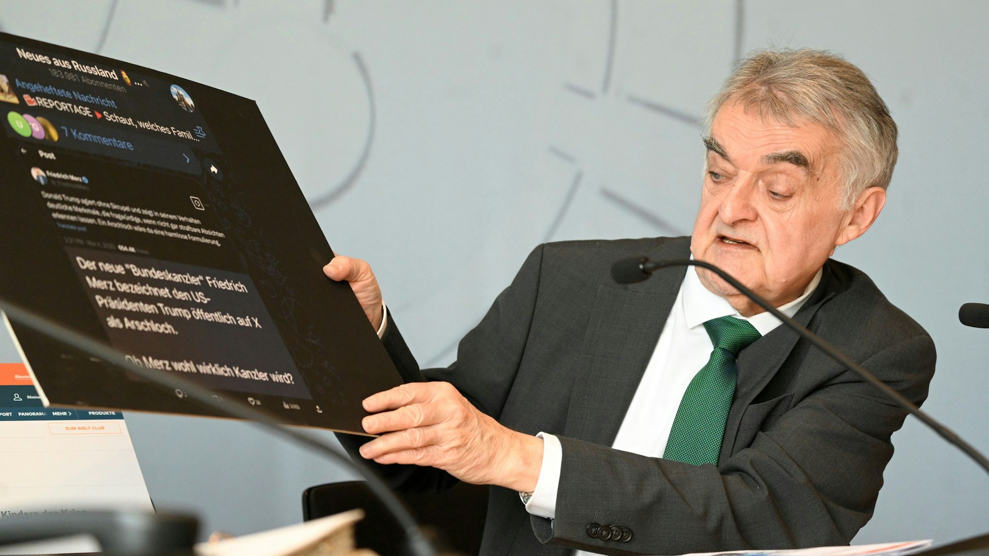 Herbert Reul(CDU), Innenminister von Nordrhein-Westfalen, zeigt eine Tafel mit Fake-Nachrichten aus dem Internet bei der Vorstellung des Verfassungsschutzbericht 2024 des Landes.
