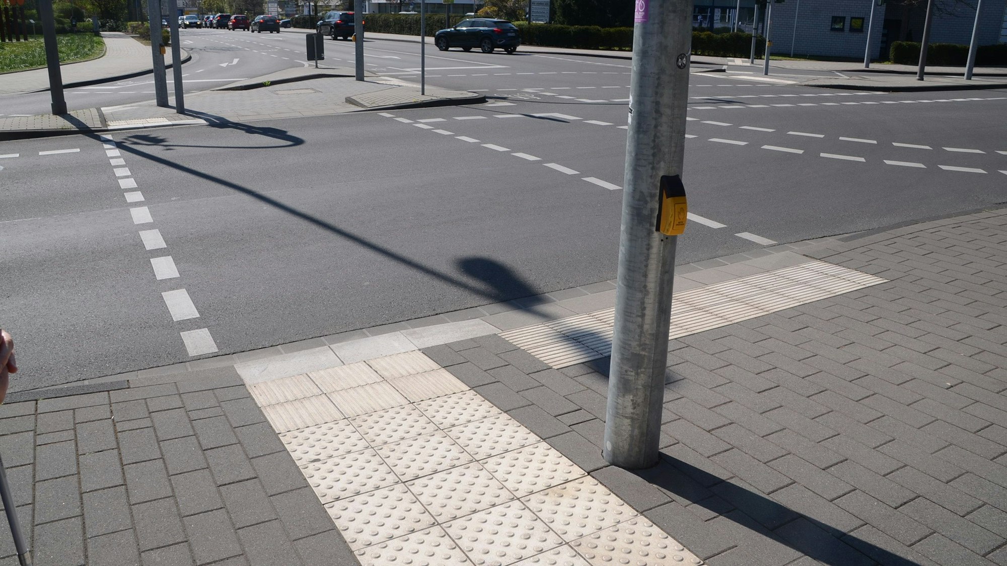 Ein Überweg an der Stadthalle: links der Streifen für Sehbehinderte und Blinde, die abschließende Kante ist drei Zentimeter hoch und mit dem Stock tastbar. Rechts gibt es keine derartige Kante und mit den Querrillen das Signal, stehen zu bleiben.