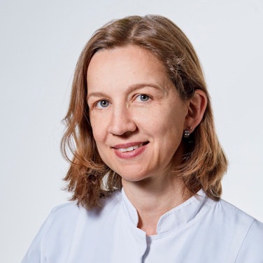 Eine Ärztin trägt einen weißen Kittel.