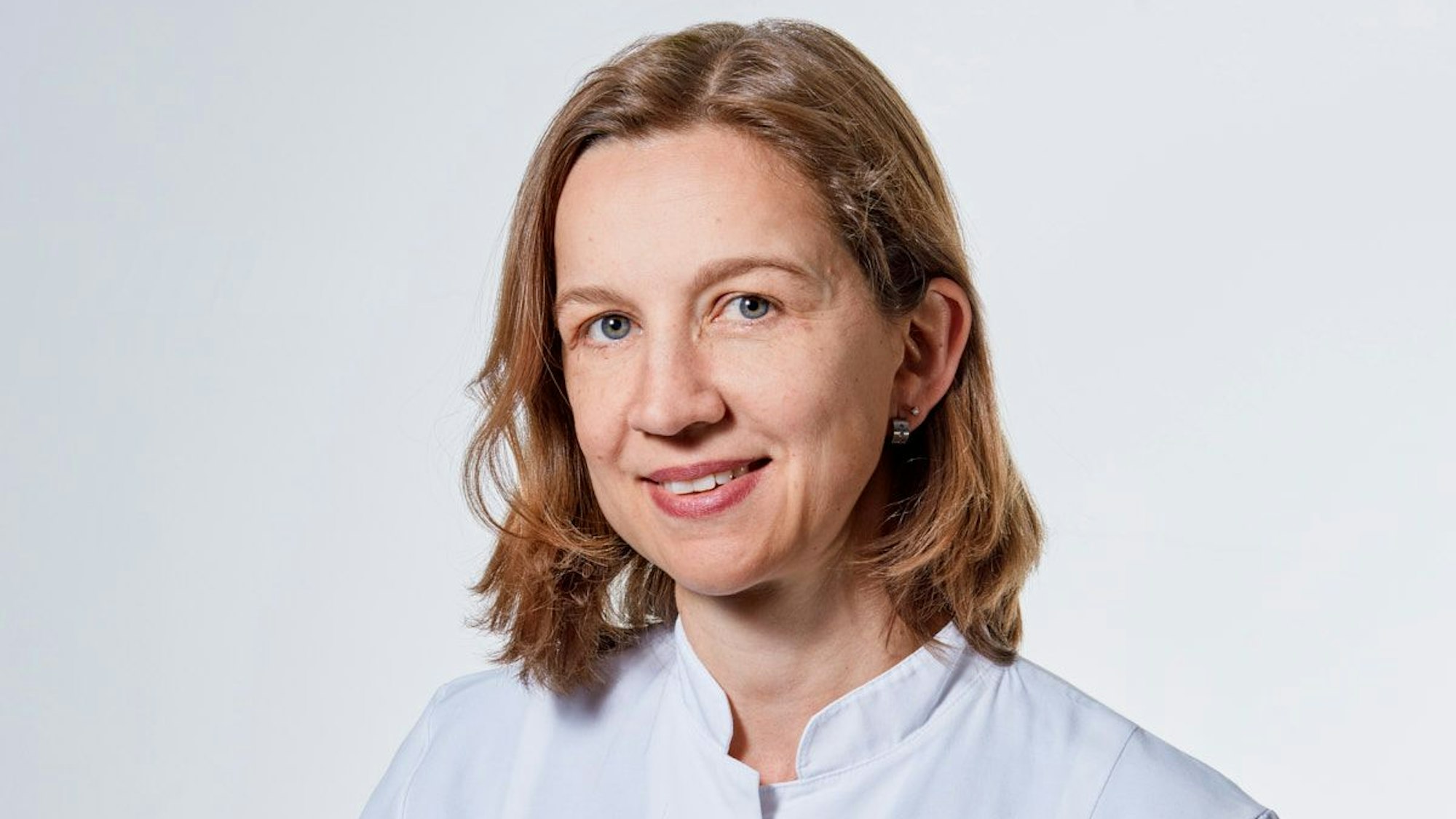 Eine Ärztin trägt einen weißen Kittel.