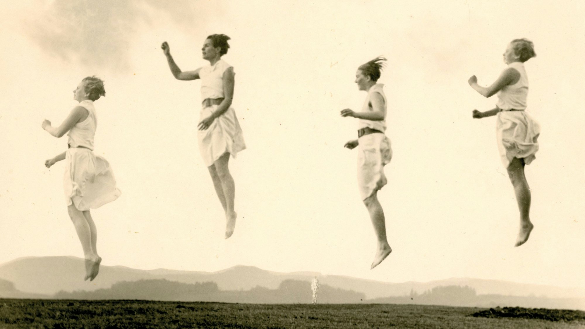 Vier springende Frauen scheinen in der Luft zu stehen.