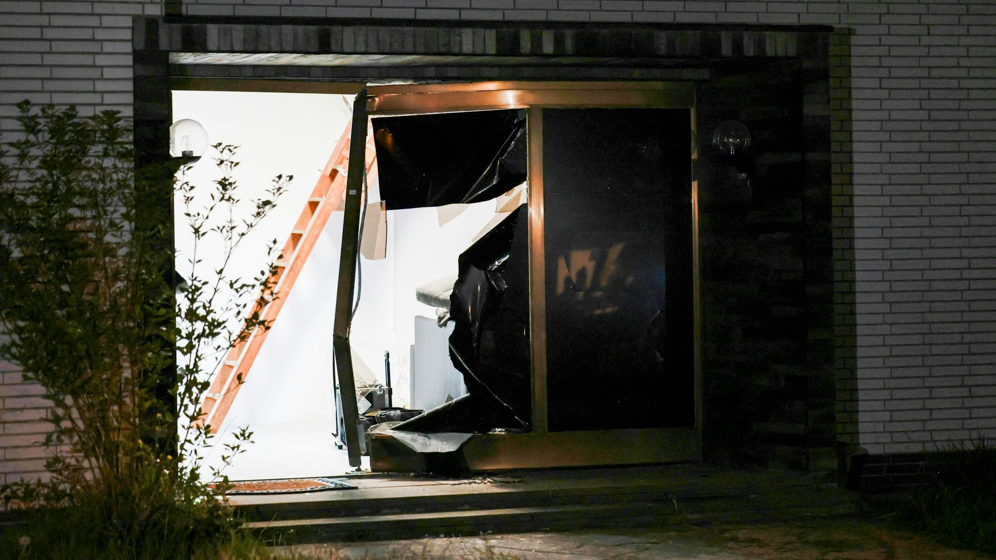Blick auf den beschädigten Eingang eines Hauses nach einer Durchsuchung durch die Polizei.