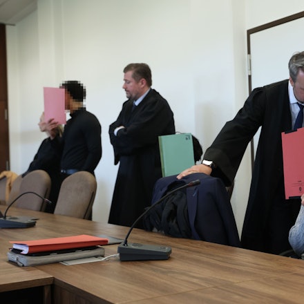 Die drei Angeklagten mit ihren Verteidigern beim Prozessauftakt im Kölner Landgericht