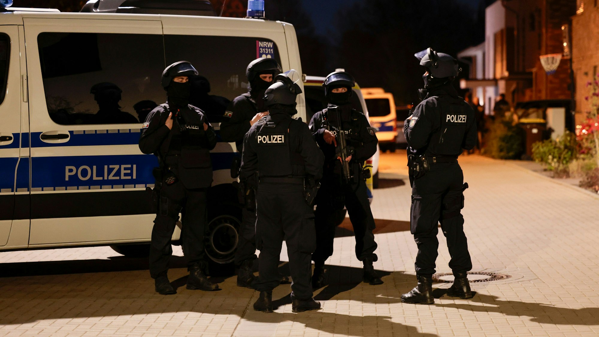 Einsatzkräfte der Polizei sind bei der Durchsuchung eines Hauses im Einsatz.