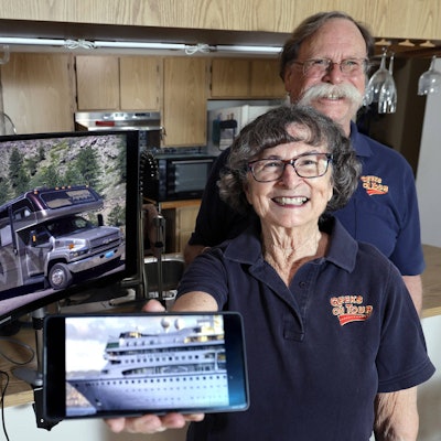 Chris und Jim Guld aus Florida stehen vor einem Bildschirm mit ihrem Van und halten ein Bild von dem Kreuzfahrtschiff in die Kamera.