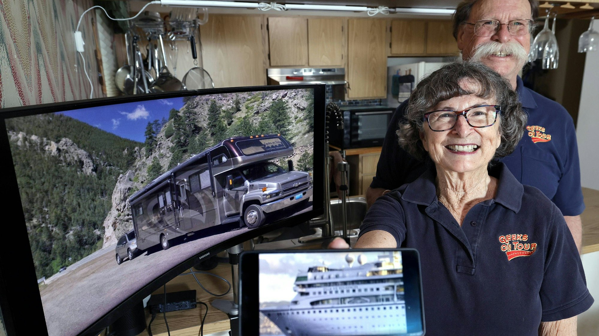 Chris und Jim Guld aus Florida stehen vor einem Bildschirm mit ihrem Van und halten ein Bild von dem Kreuzfahrtschiff in die Kamera.