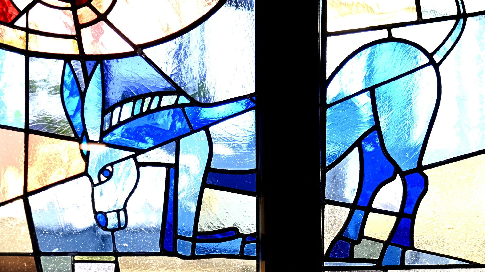 Buntes Glasfenster des Gasthauses mit blauem Esel