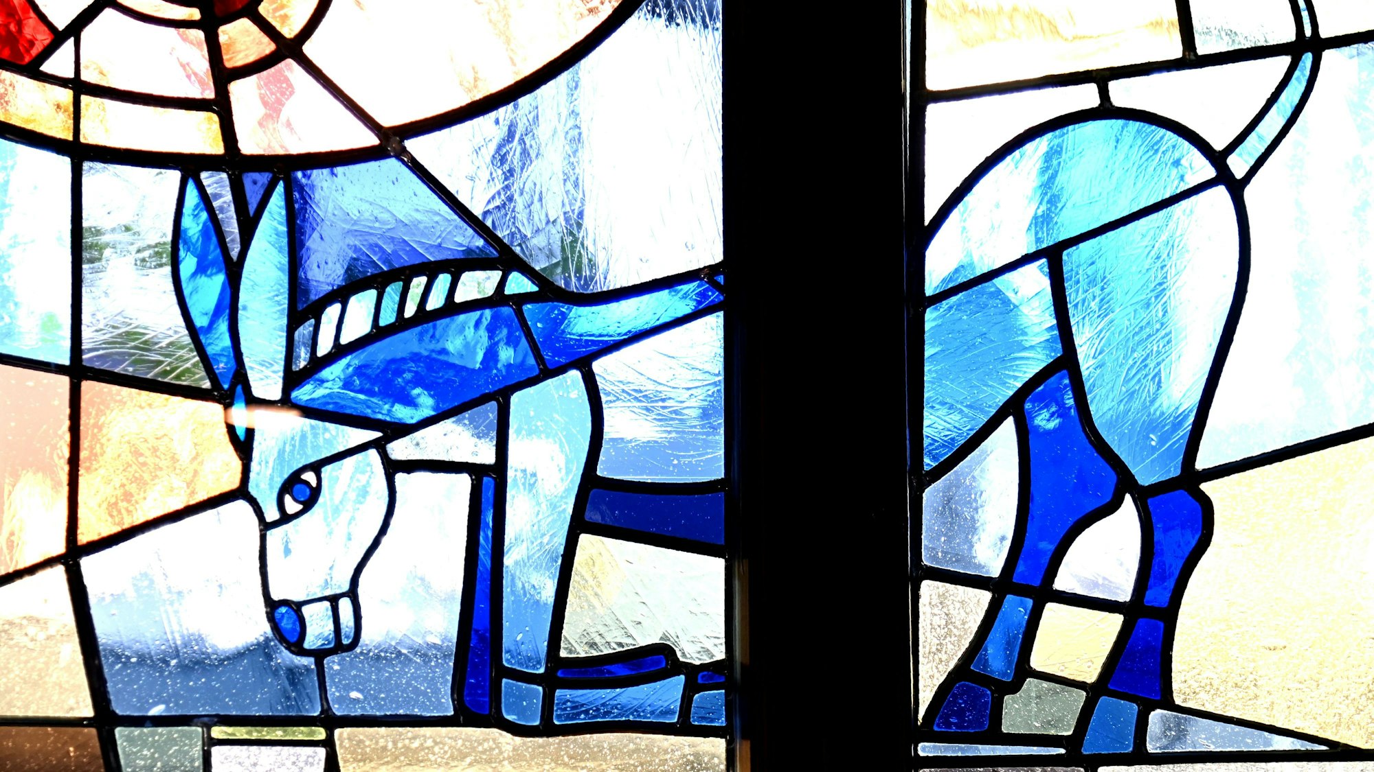 Buntes Glasfenster des Gasthauses mit blauem Esel