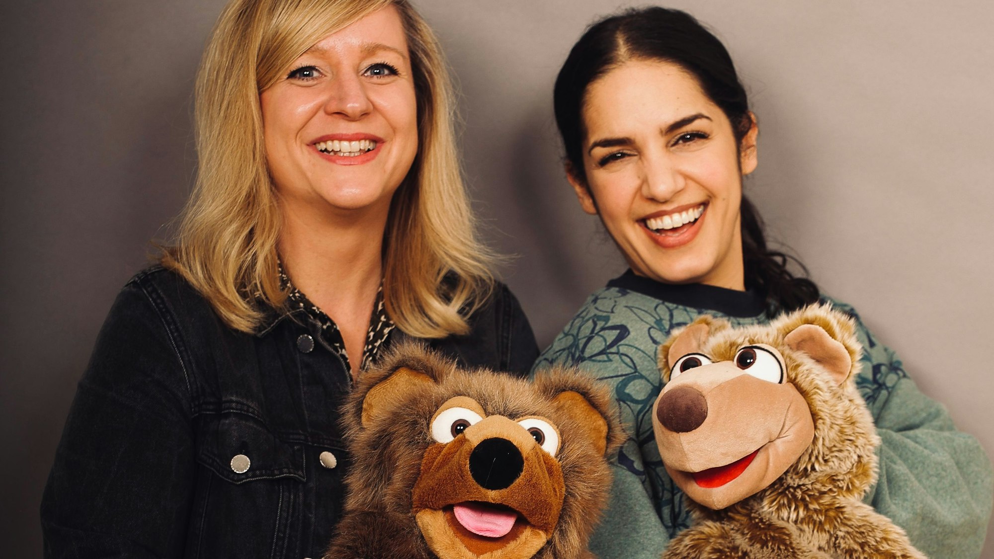 Die pädagogischen Fachkräfte des Kölner Kinderschutzbunds Britta Niessen und Yamam Najim halten die beiden Bären-Handpuppen Bärt und Bärta in der Hand.