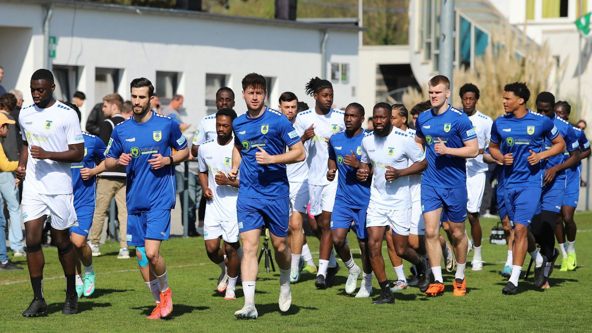 Fußballer joggen über einen Platz.