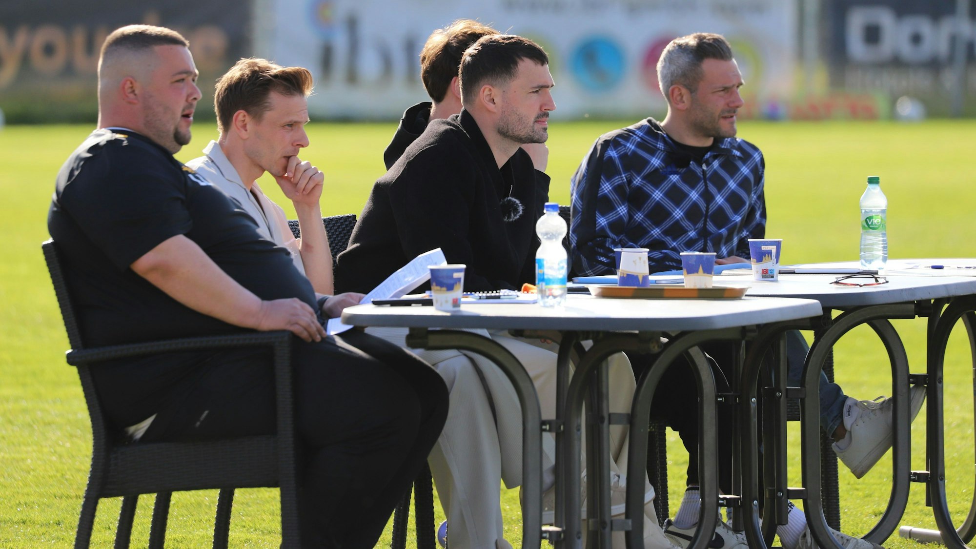Fünf Männer sitzen an einem Tisch.