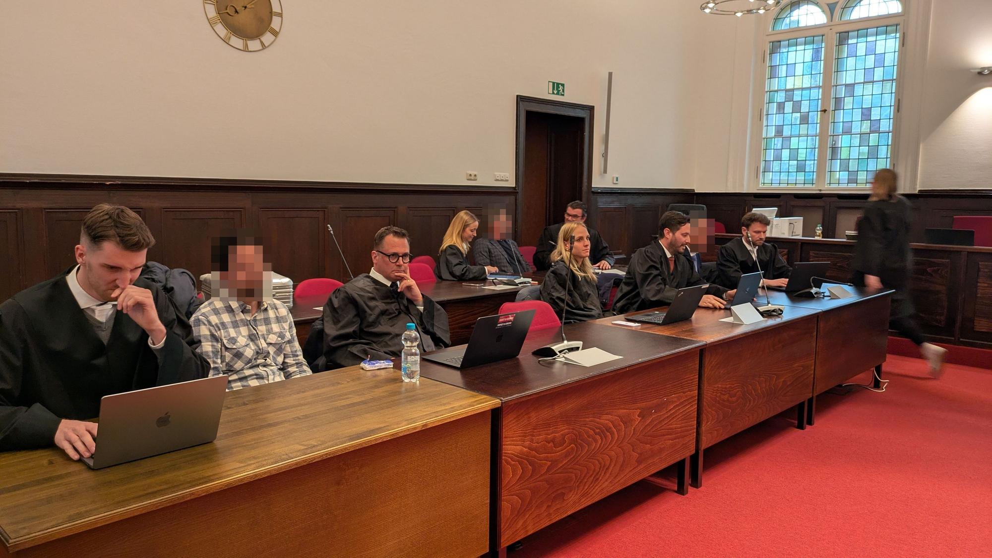 Angeklagte und Verteidiger sitzen im Gerichtssaal.