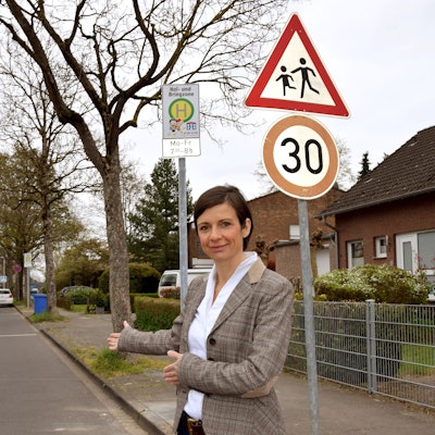 Eine Frau steht vor einer eingezeichneten Parkfläche.