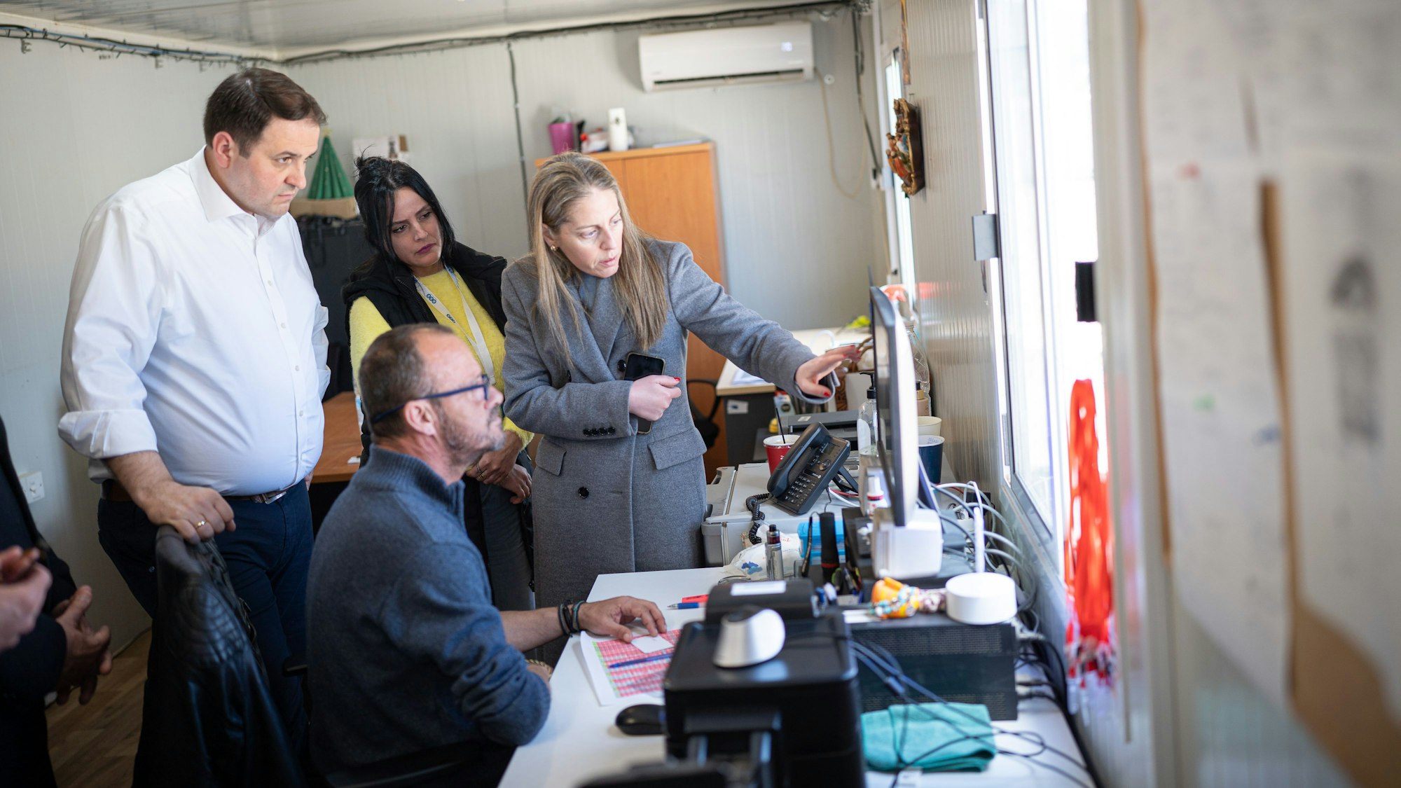 NRW-Europaminister Nathanael Liminski lässt sich den Registrierungsprozess im Flüchtlingscamp Malakasa bei Athen erklären.