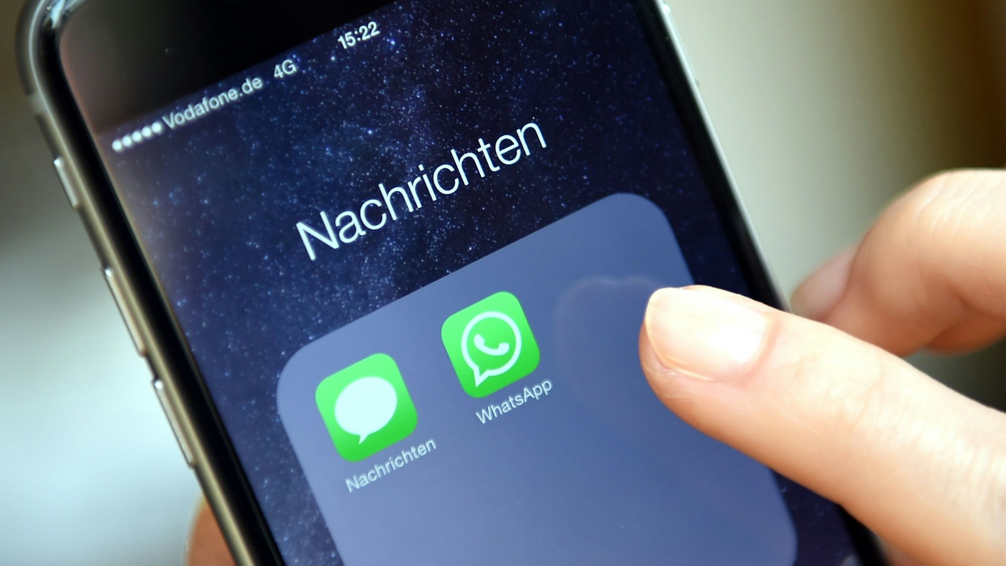Auf dem Display eines iPhone werden die Symbole der Apps „WhatsApp“ und „Nachrichten“ angezeigt.