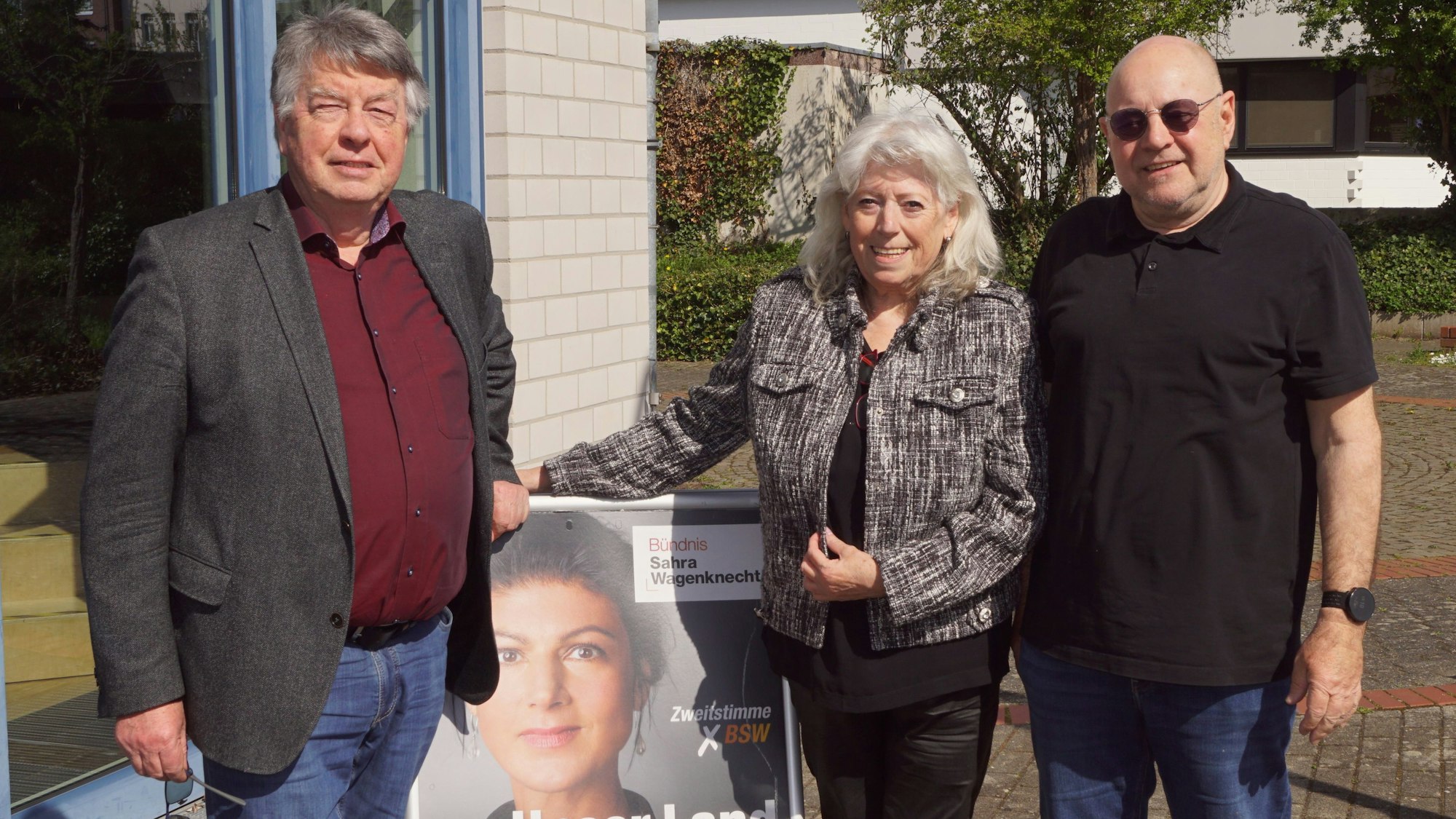 Auf dem Foto sind zwei Männer und eine Frau zu sehen.