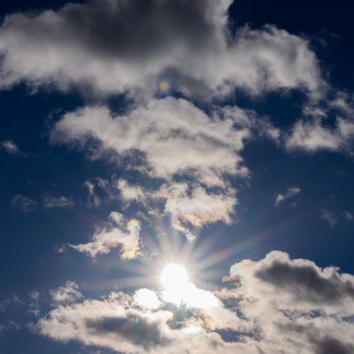 Die Sonne scheint zwischen Wolken hindurch.