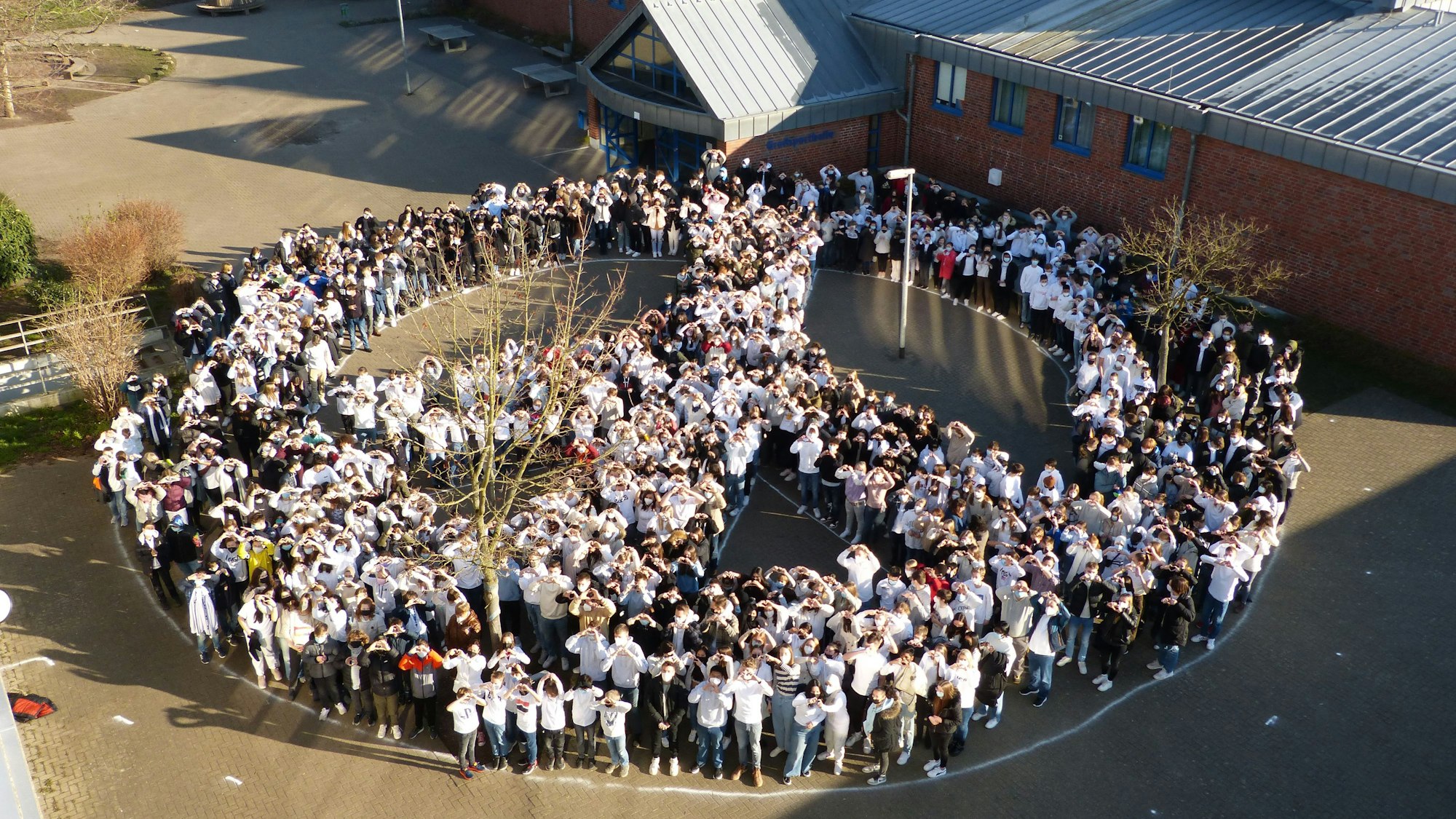 Schülerinnen und Schüler des Gutenberg-Gymnasiums in Bergheim formten 2022 als Reaktion auf den russischen Überfall auf die Ukraine auf dem Schulhof ein Peace-Zeichen.