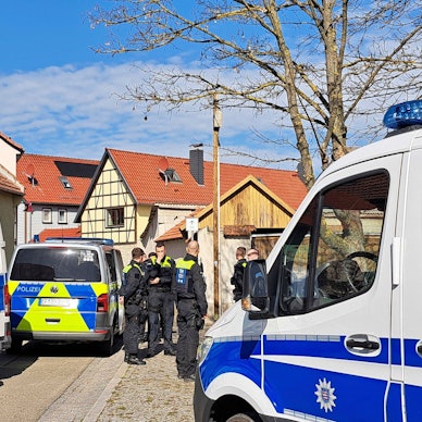 Polizeibeamte sichern die Umgebung um einen Tatort in Klettbach. Vier Menschen sind im thüringischen Klettbach im Weimarer Land tot aufgefunden worden. Das bestätigte ein Sprecher der Staatsanwaltschaft Erfurt.