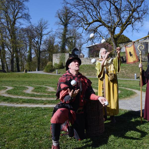 Mittelalterlich gekleidete Akteure vor dem Schloss.