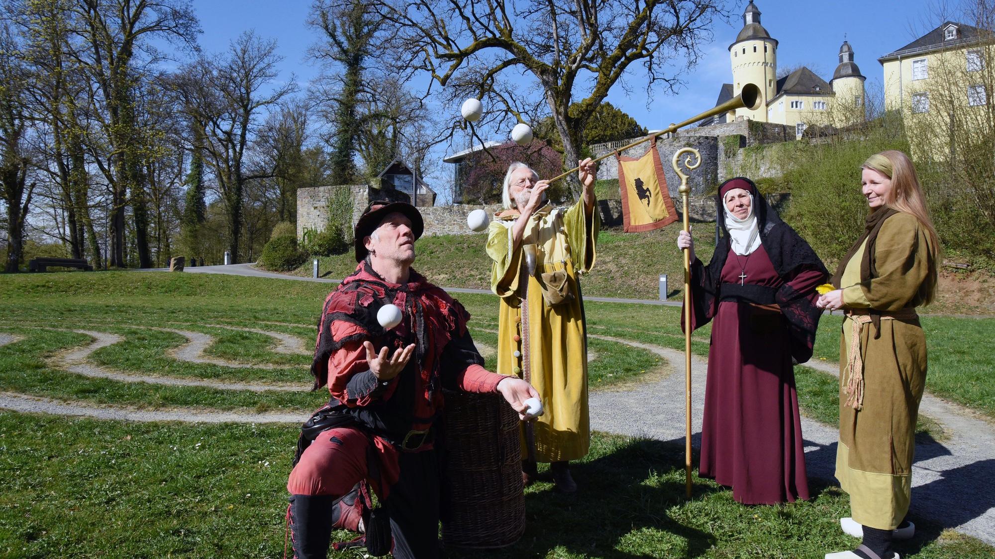 Mittelalterlich gekleidete Akteure vor dem Schloss.