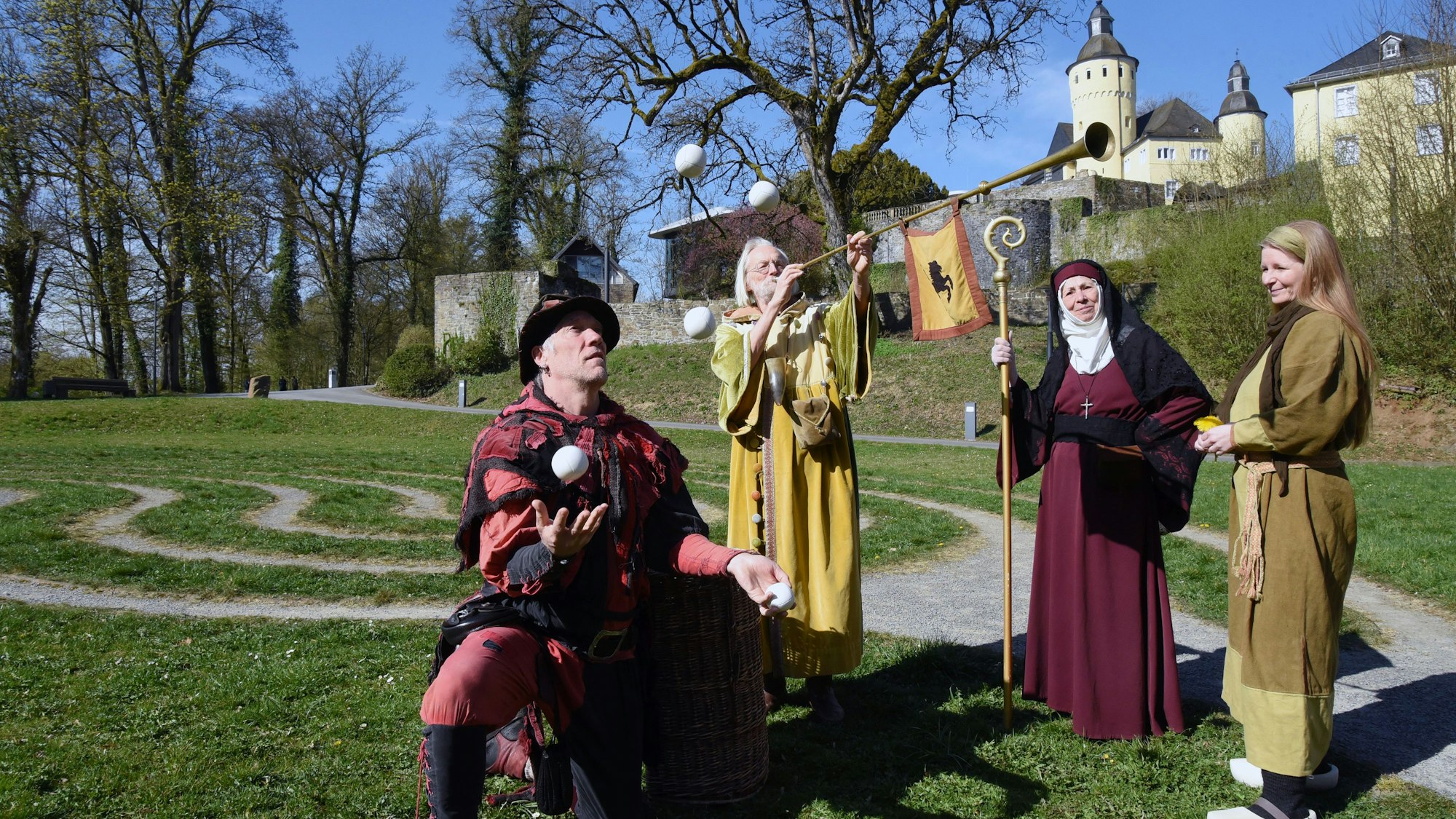 Mittelalterlich gekleidete Akteure vor dem Schloss.