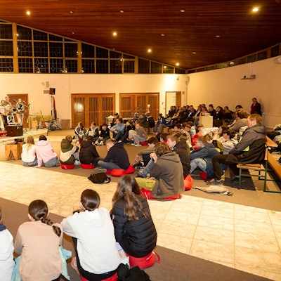 Die rund 60 Teilnehmer sitzen in der Jugendkirche auf Stühlen und auf dem Boden.