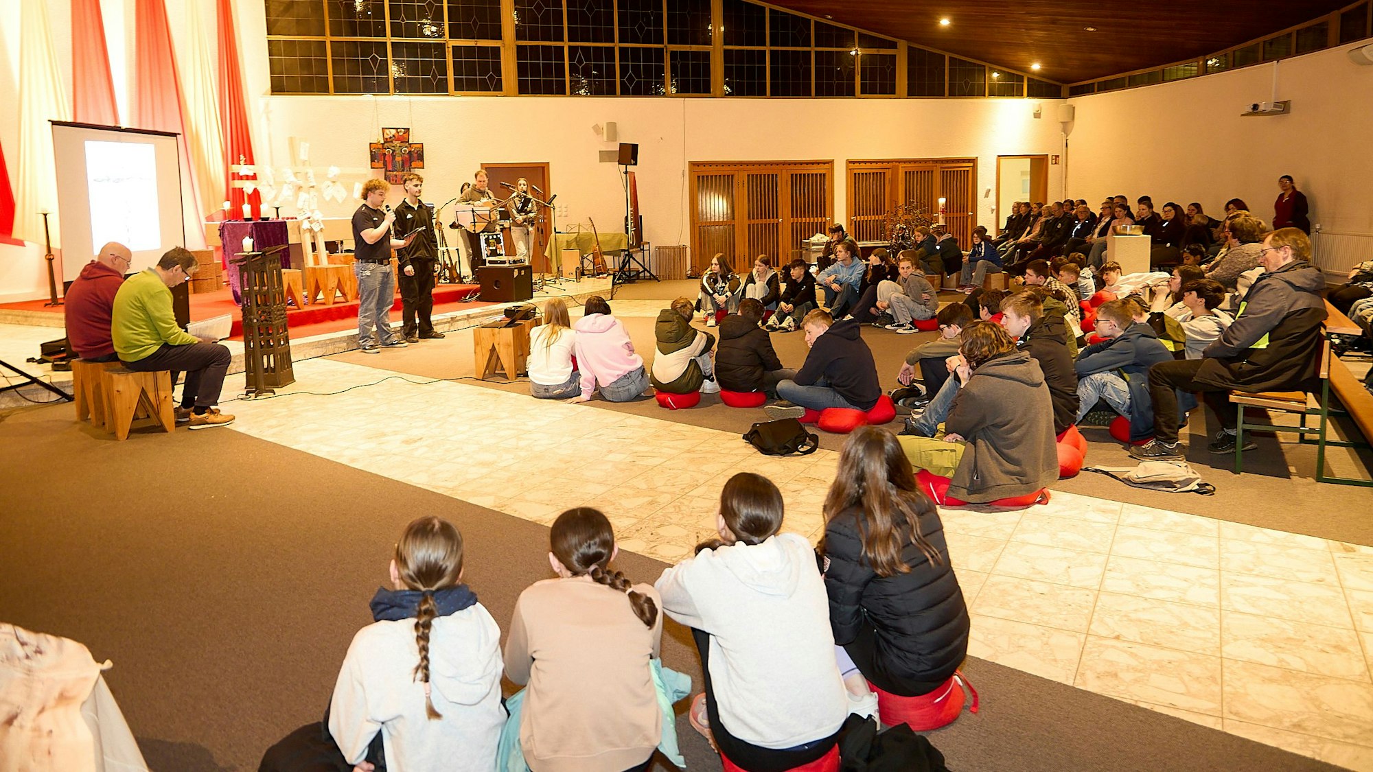 Die rund 60 Teilnehmer sitzen in der Jugendkirche auf Stühlen und auf dem Boden.
