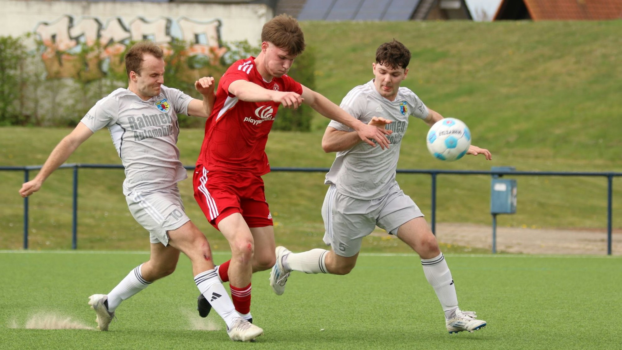 Julian Eversheim plustert die Backen auf, während er von einem Gegenspieler attackiert wird.