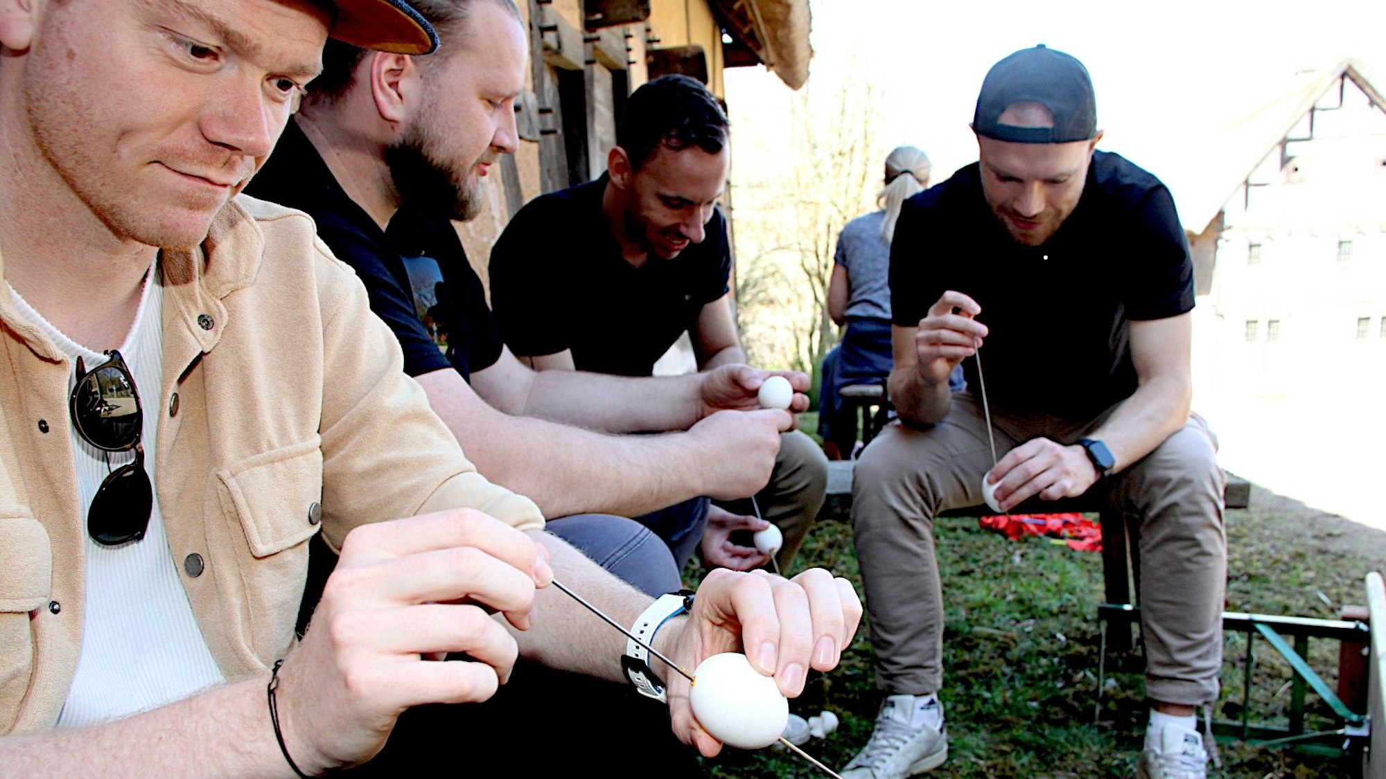 Das Bild zeigt vier Männer beim Durchstechen der Eier.