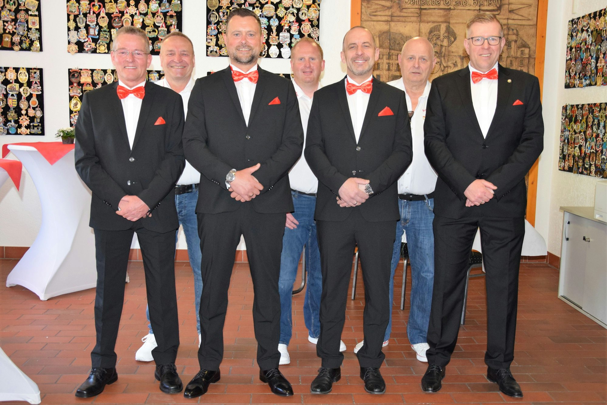 Sieben Männer lächeln in die Kamera.