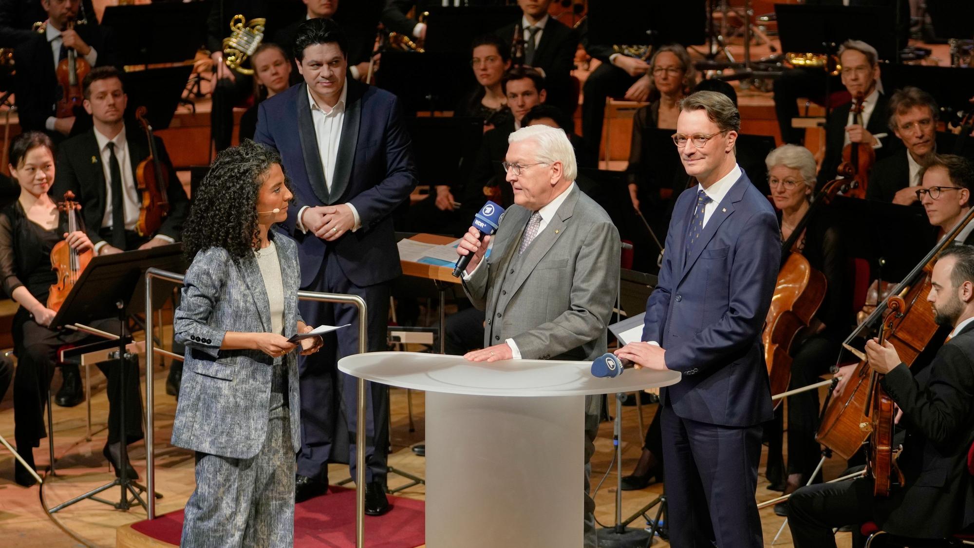 Bundespräsident Frank-Walter Steinmeier (M) und NRW-Ministerpräsident Hendrik Wüst (CDU) sprechen mit Fernsehmoderatorin Siham El-Maimouni beim traditionellen Benefizkonzert des Bundespräsidenten.