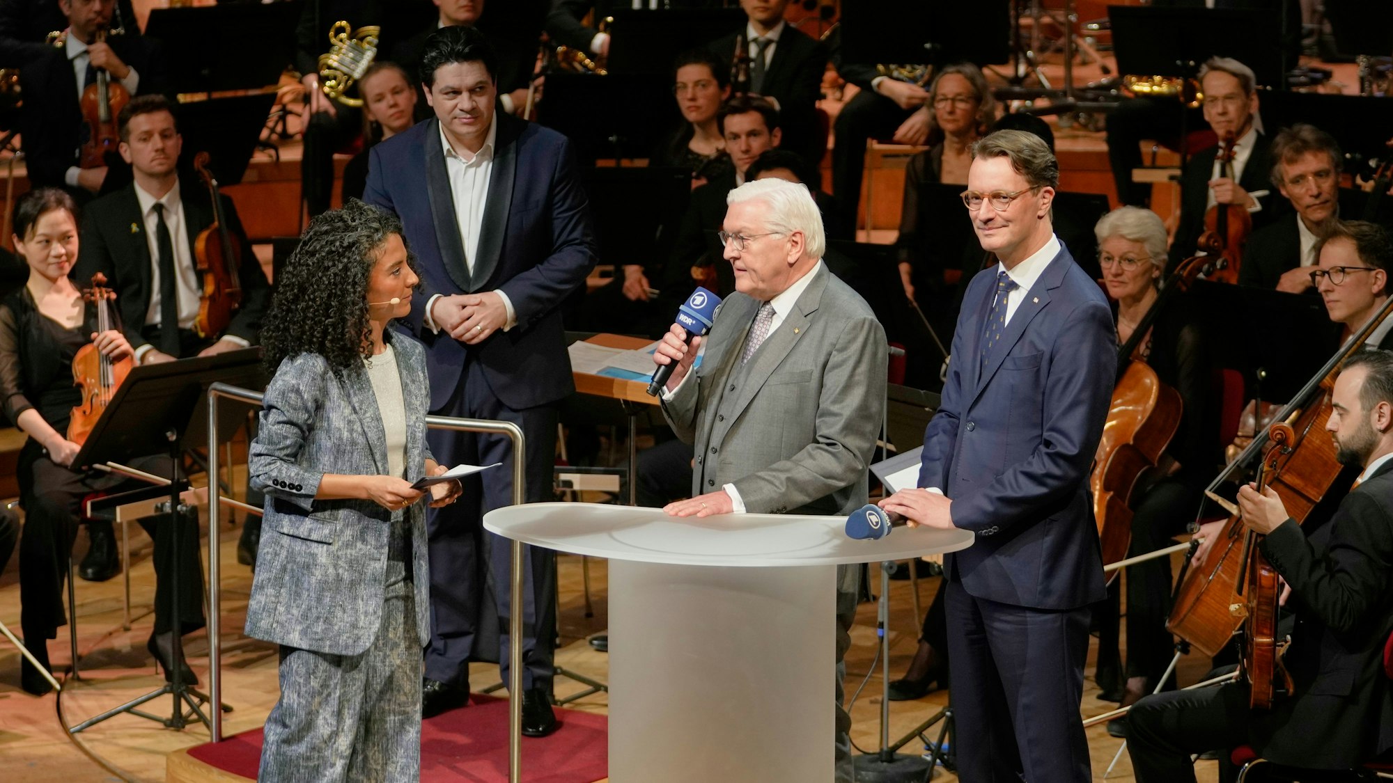 Bundespräsident Frank-Walter Steinmeier (M) und NRW-Ministerpräsident Hendrik Wüst (CDU) sprechen mit Fernsehmoderatorin Siham El-Maimouni beim traditionellen Benefizkonzert des Bundespräsidenten.