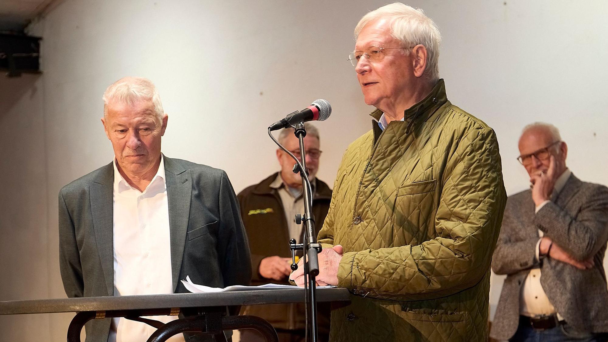 Dr. Karl-Heinz Feldmann steht neben einem Rednerpult, an dem Eckhard Uhlenberg spricht.
