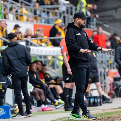 Ein Fußballtrainer versucht, seine Mannschaft zu beruhigen.