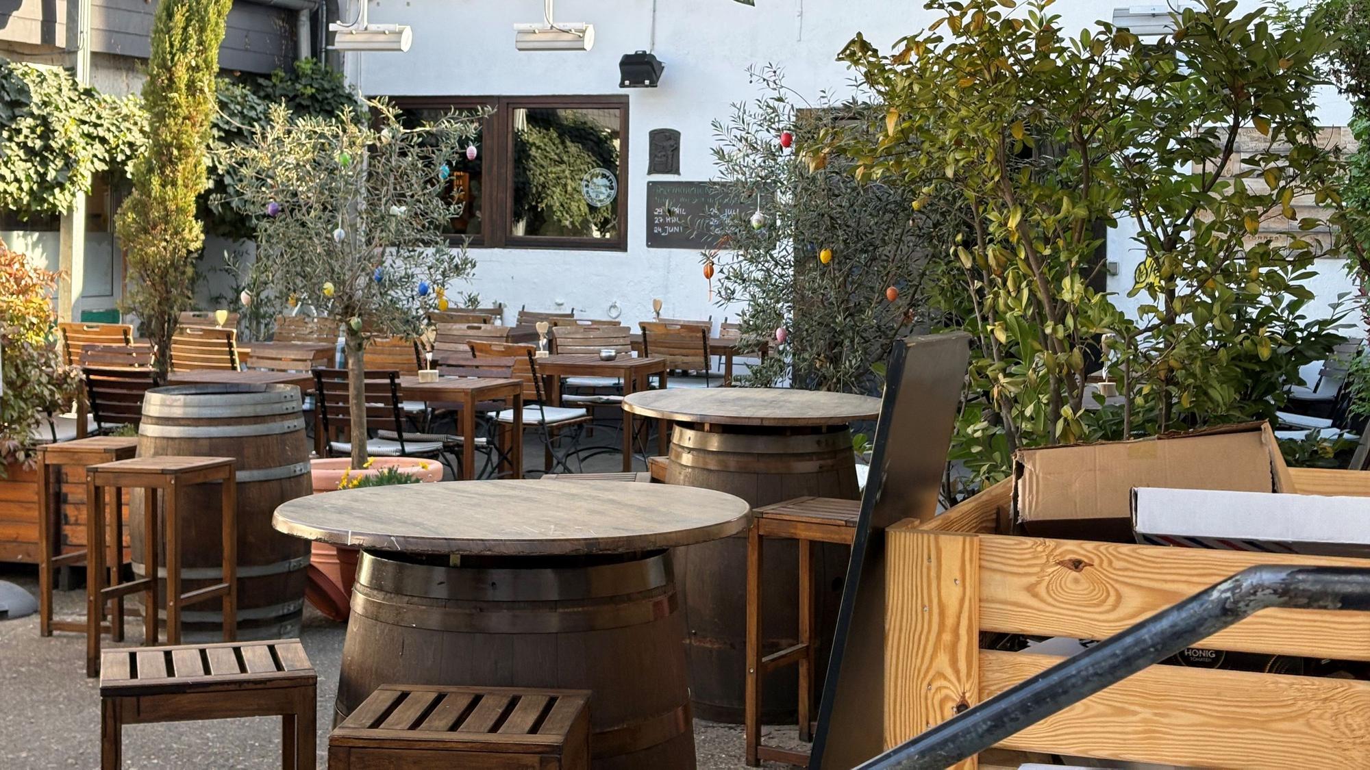 Außenbereich des Bistro Verde in Rodenkirchen mit Holztischen und Stühlen.