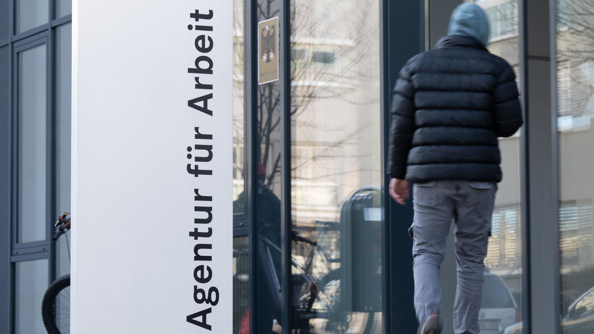 ARCHIV - 03.01.2023, Sachsen, Dresden: Ein Mann geht hinter einer Stele mit der Aufschrift «Agentur für Arbeit». Neue ukrainische Flüchtlinge sollen keinen Anspruch auf Bürgergeld mehr haben. (zu dpa: «Kein Bürgergeld für neue Kriegsflüchtlinge aus der Ukraine») Foto: Sebastian Kahnert/dpa +++ dpa-Bildfunk +++