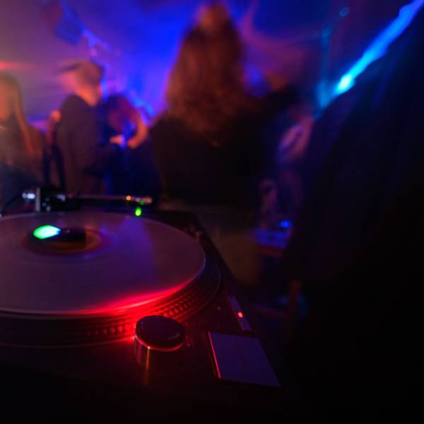 Partygänger tanzen vor einem DJ-Pult in einem Club. (Symbolbild)