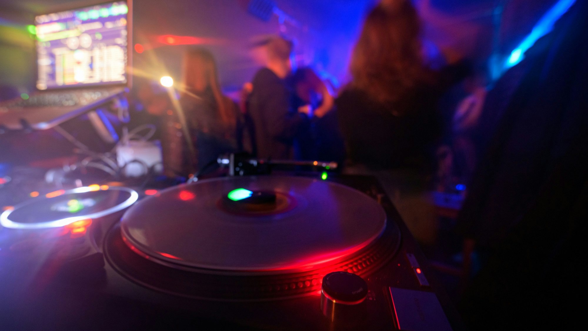 Partygänger tanzen vor einem DJ-Pult in einem Club. (Symbolbild)