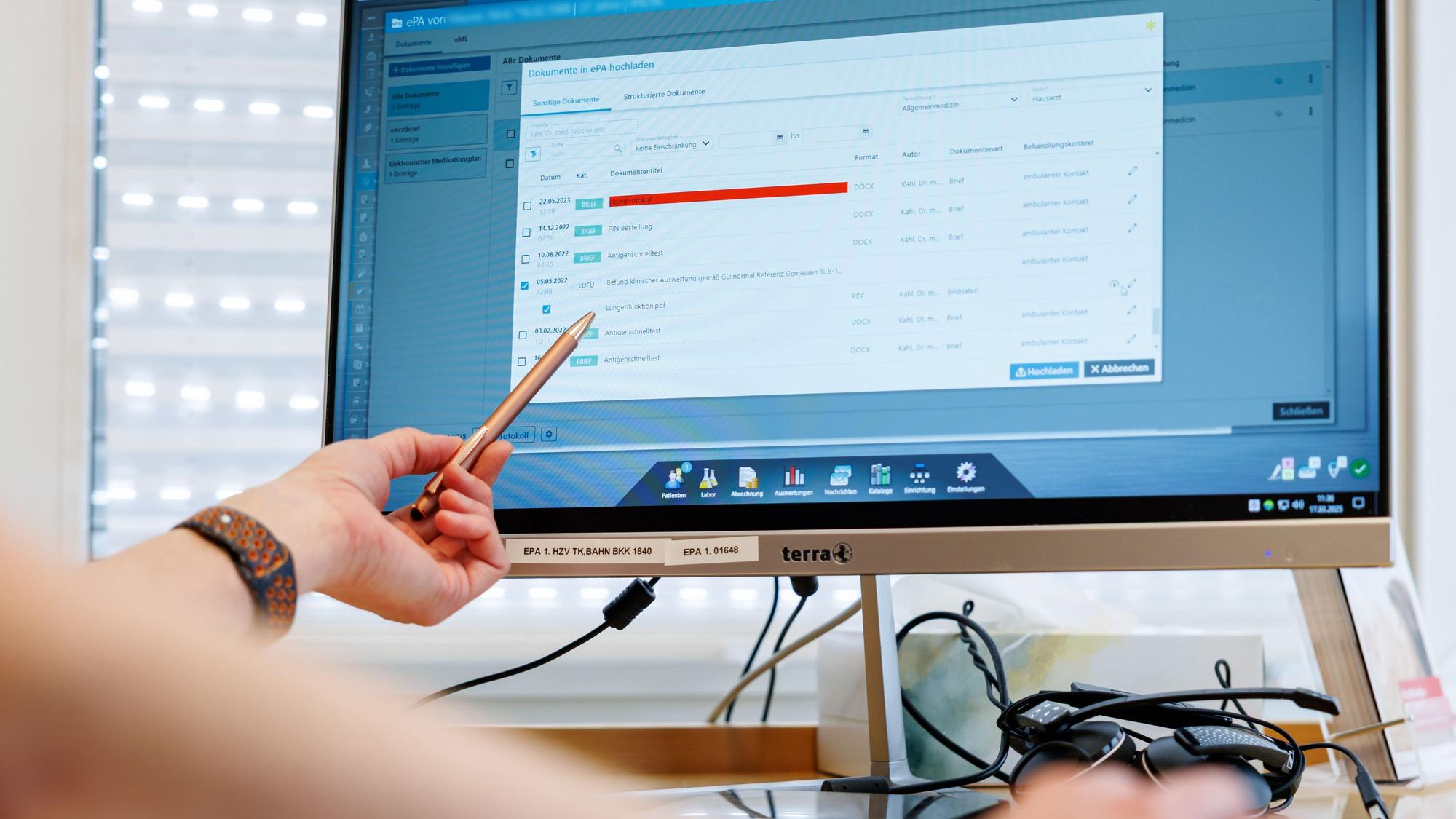 PRODUKTION - 17.03.2025, Bayern, Nürnberg: Ein Hausarzt lädt in seiner Praxis Dokumente in eine elektronische Patientenakte "ePA". (zu dpa: «E-Patientenakte wird bundesweit verbreitet») Foto: Daniel Karmann/dpa +++ dpa-Bildfunk +++