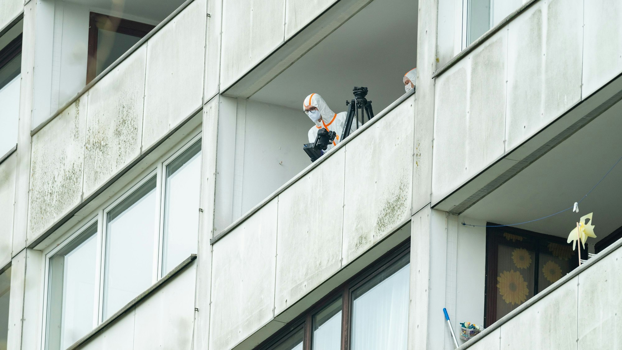14.04.2025, Hamburg: Beamte der Spurensicherung ermitteln auf einem Balkon des Hochhauses. Ein junger Mann ist in der Nacht in Hamburg-Wilsdorf vom Balkon eines Hochhauses in den Tod gestürzt. Es gebe Hinweise auf ein Fremdverschulden, sagte ein Sprecher der Polizei. (zu dpa: «Polizei ermittelt nach tödlichem Sturz von Balkon») Foto: Jonas Walzberg/dpa +++ dpa-Bildfunk +++