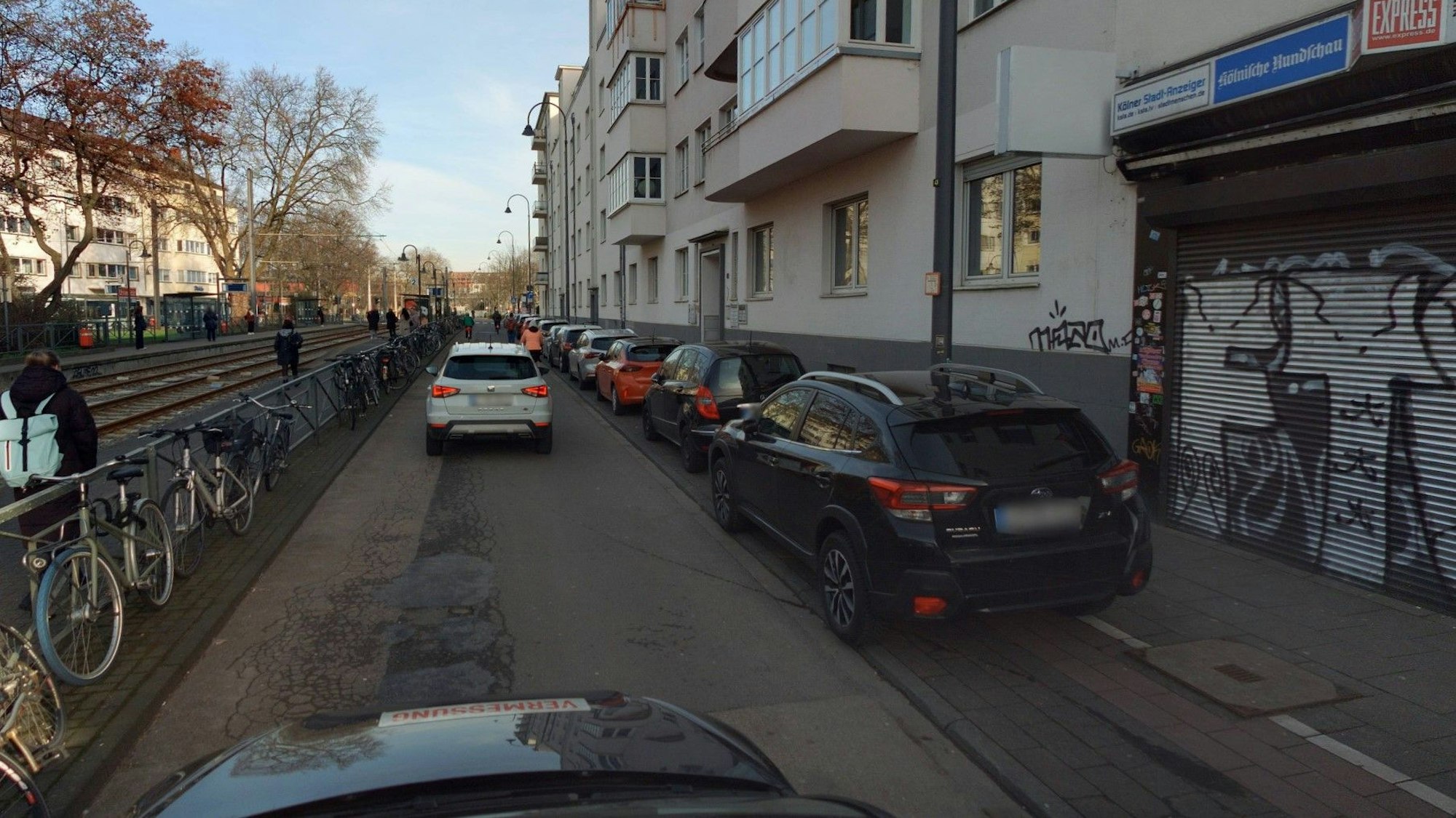 Autos fahren über einen schmalen Teil der Zülpicher Straße, der nun Fahrradstraße ist. Autos parken auf dem Radweg, der den Fußweg halbiert.