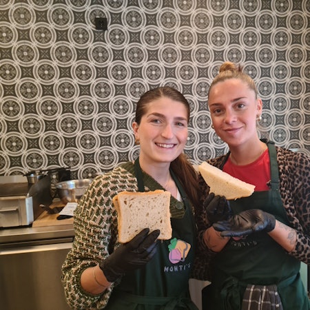 Zwei junge Frauen stehen nebeneinander. Sie halten Plus-Size-Toastscheiben hoch.