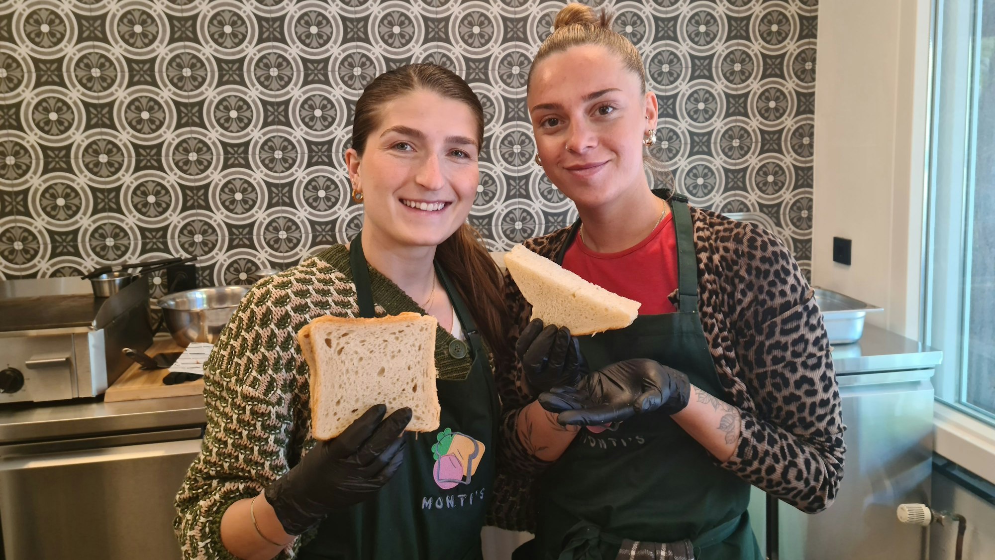 Zwei junge Frauen stehen nebeneinander. Sie halten Plus-Size-Toastscheiben hoch.