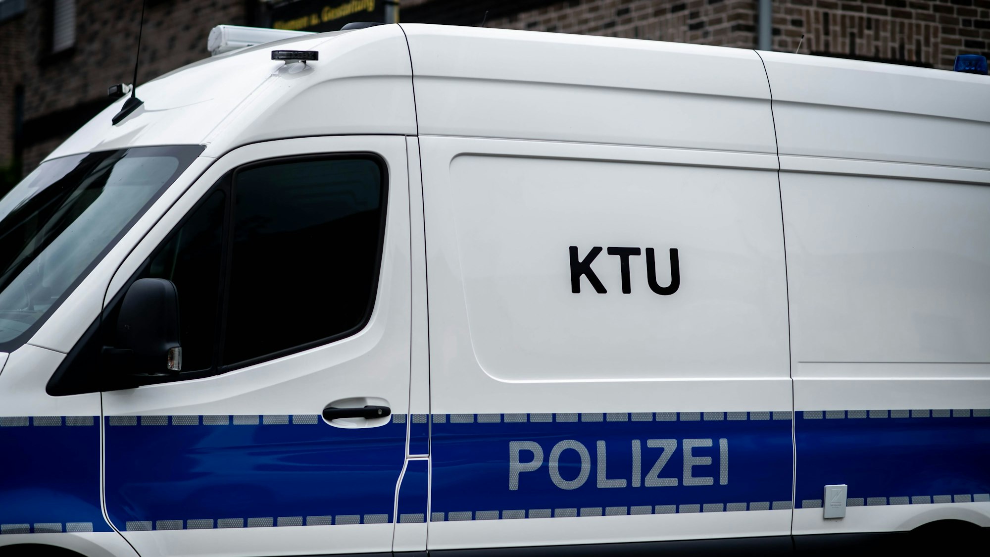 Das Bild zeigt ein Polizeifahrzeug vor einem Haus.