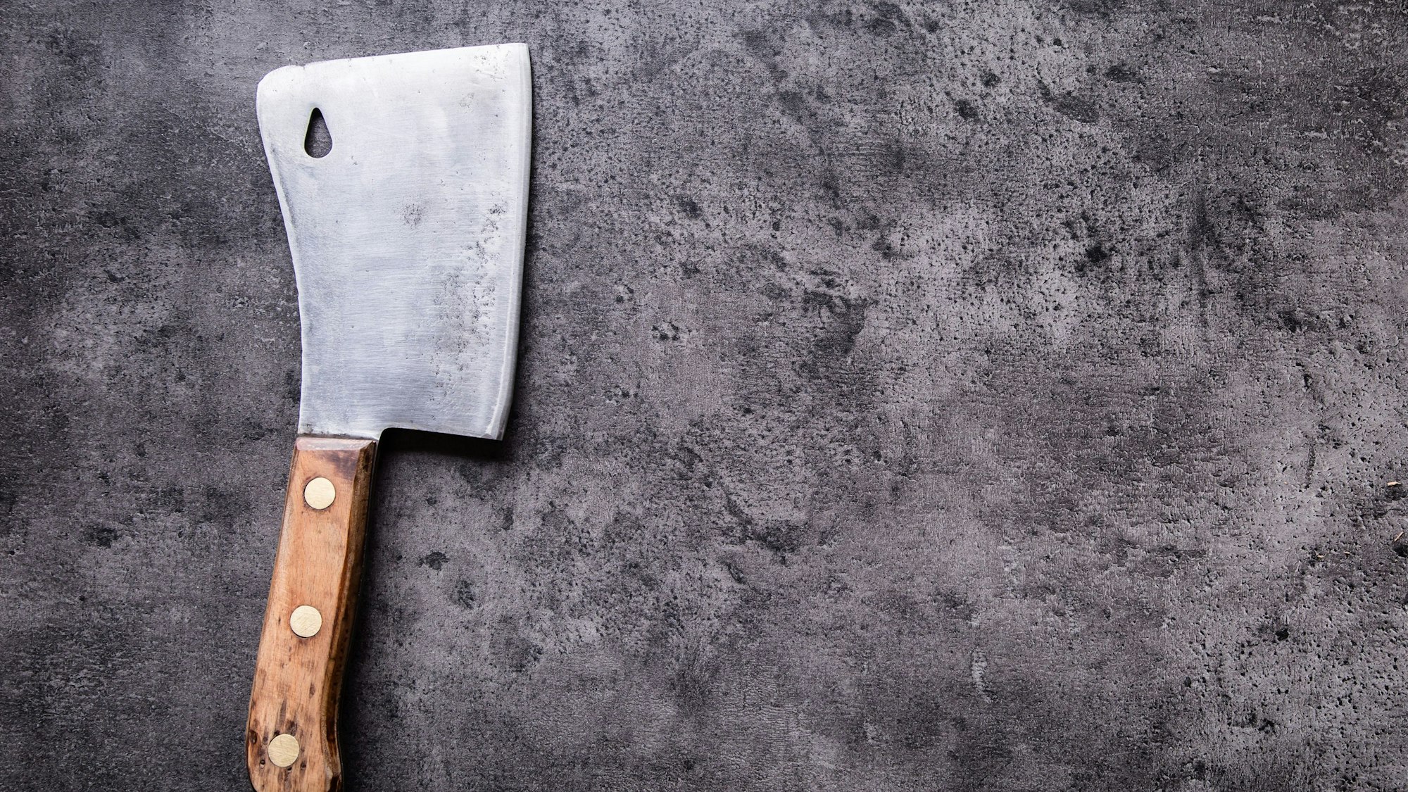 Auf einer grauen Oberfläche liegt ein Hackebeil.