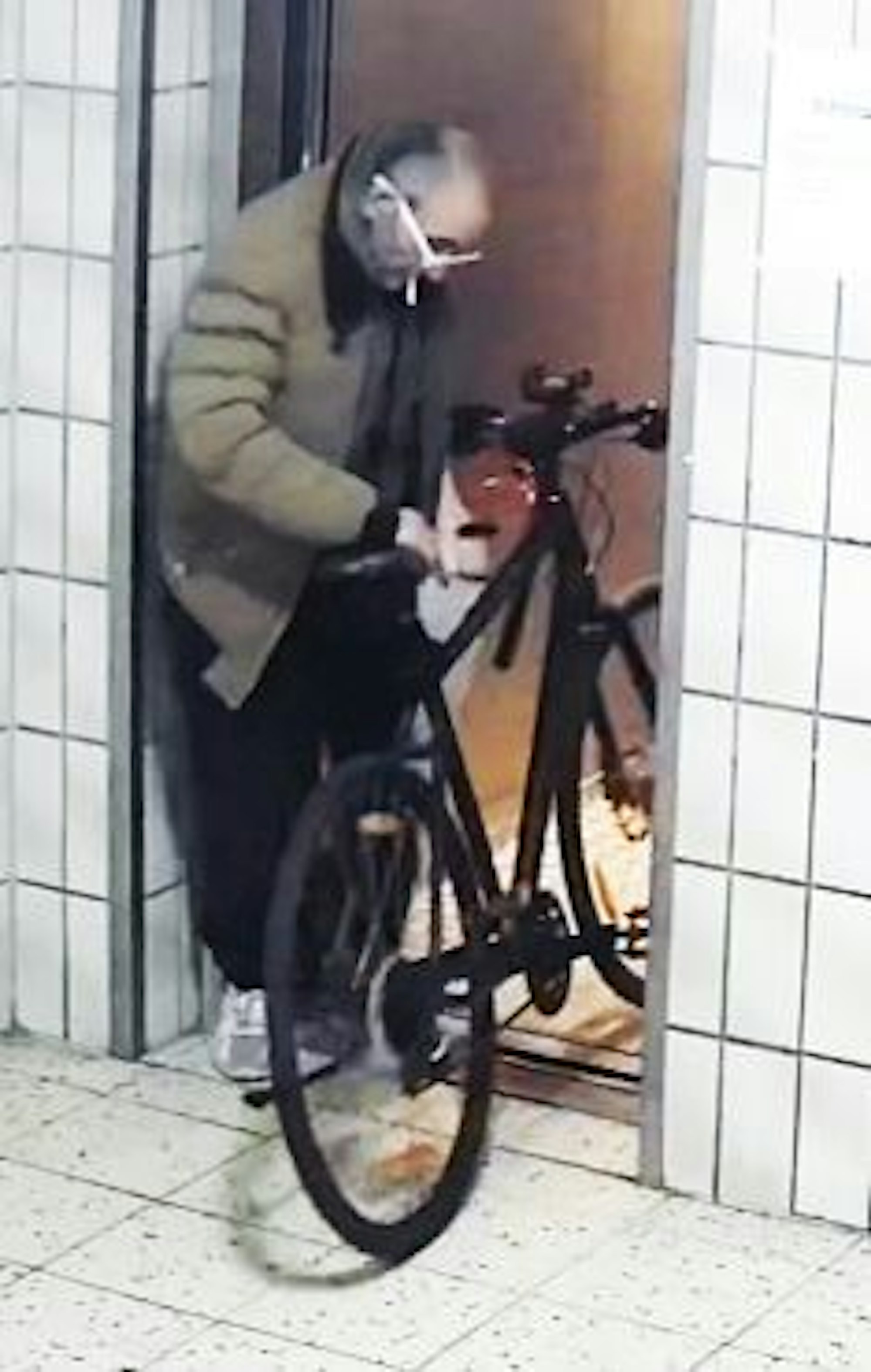 Die Polizei sucht mit Bildern nach einem Verdächtigem, der im November 2024 in Köln-Meschenich die Wohnungstür in einem Hochhaus angezündet haben soll.