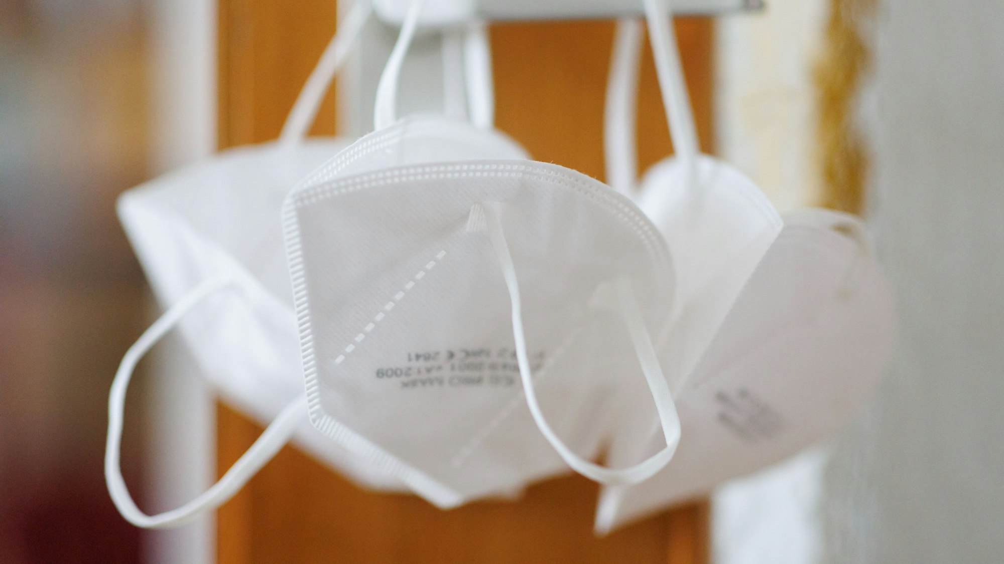 FFP2-Masken hängen an einer Türklinke. (Archivbild)