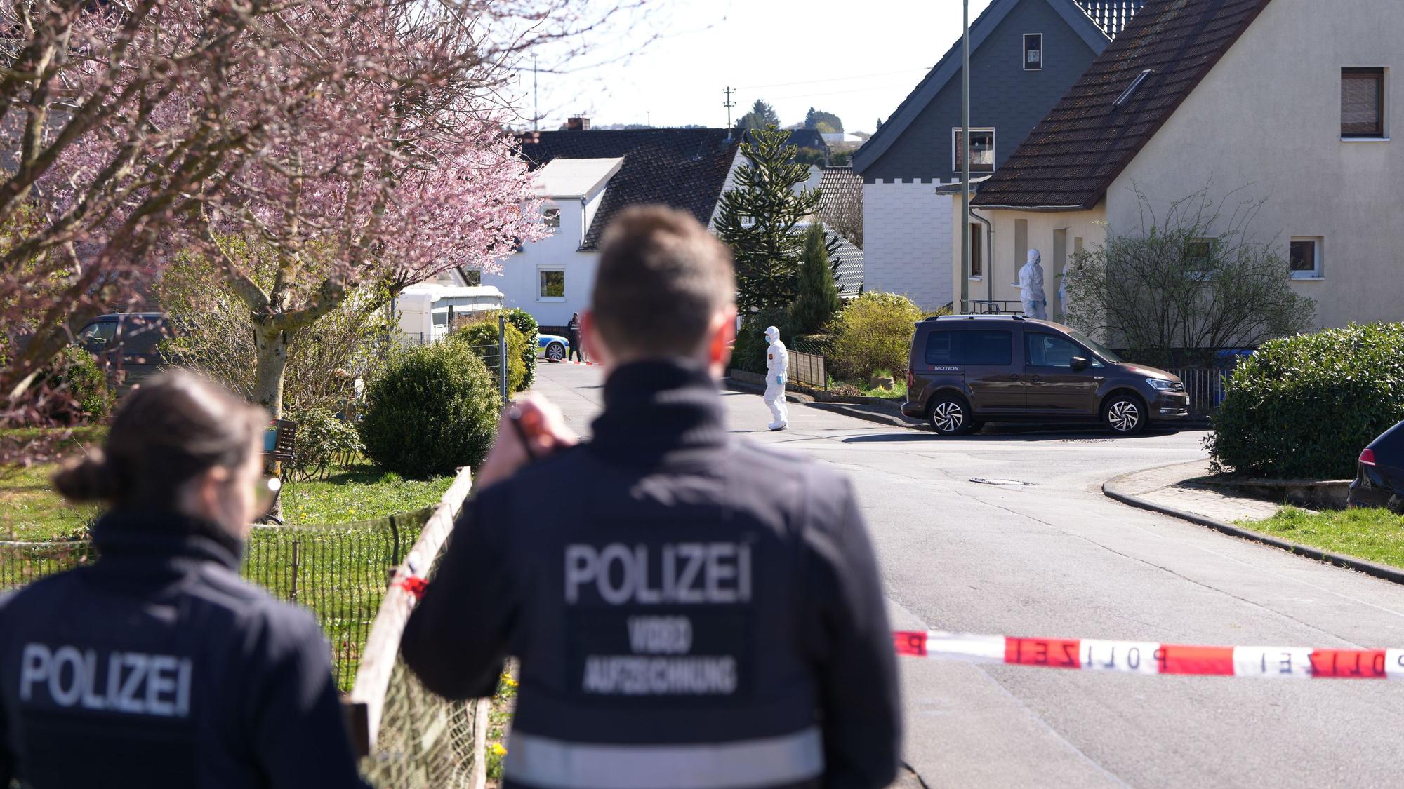 Polizei und Mitarbeiter der Spurensicherung stehen in Weitefeld am Tatort.