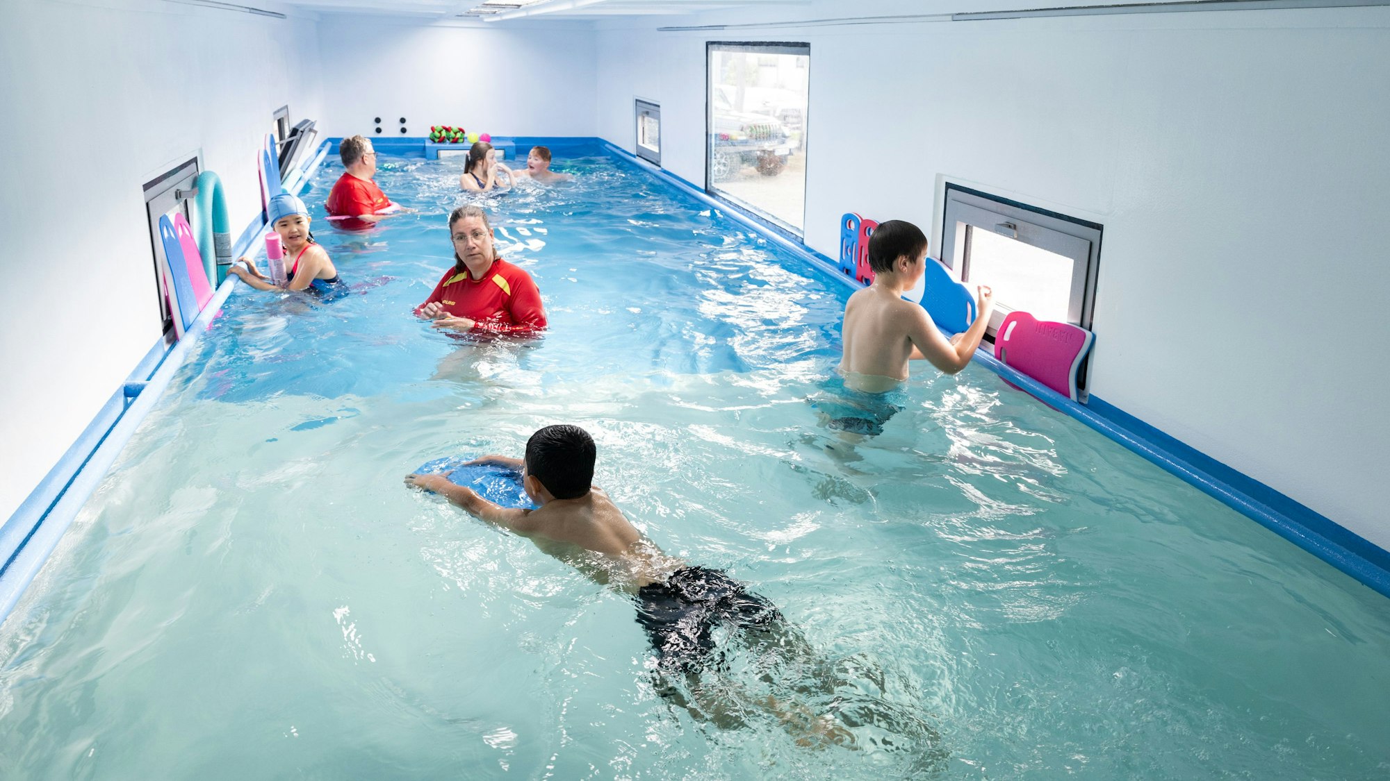 Kinder lernen in einem Container schwimmen.
